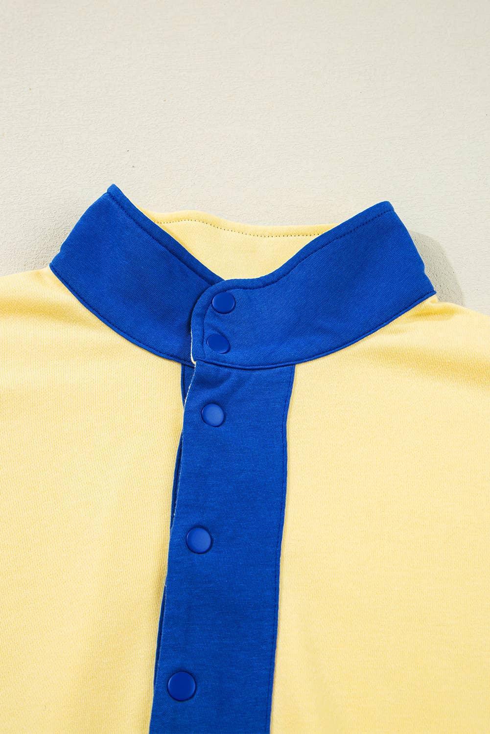 Yellow shirt with blue collar and snap button placket, colorblock fashion detail.