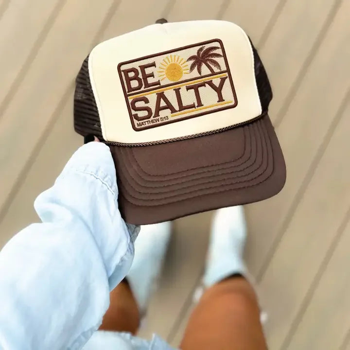 Brown and beige trucker hat with 'Be Salty' text, sun, and palm tree graphic design.