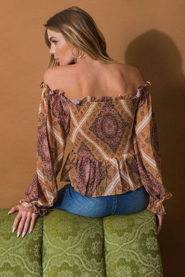 Boho off-shoulder top with geometric print, long sleeves, and ruffled details paired with denim shorts