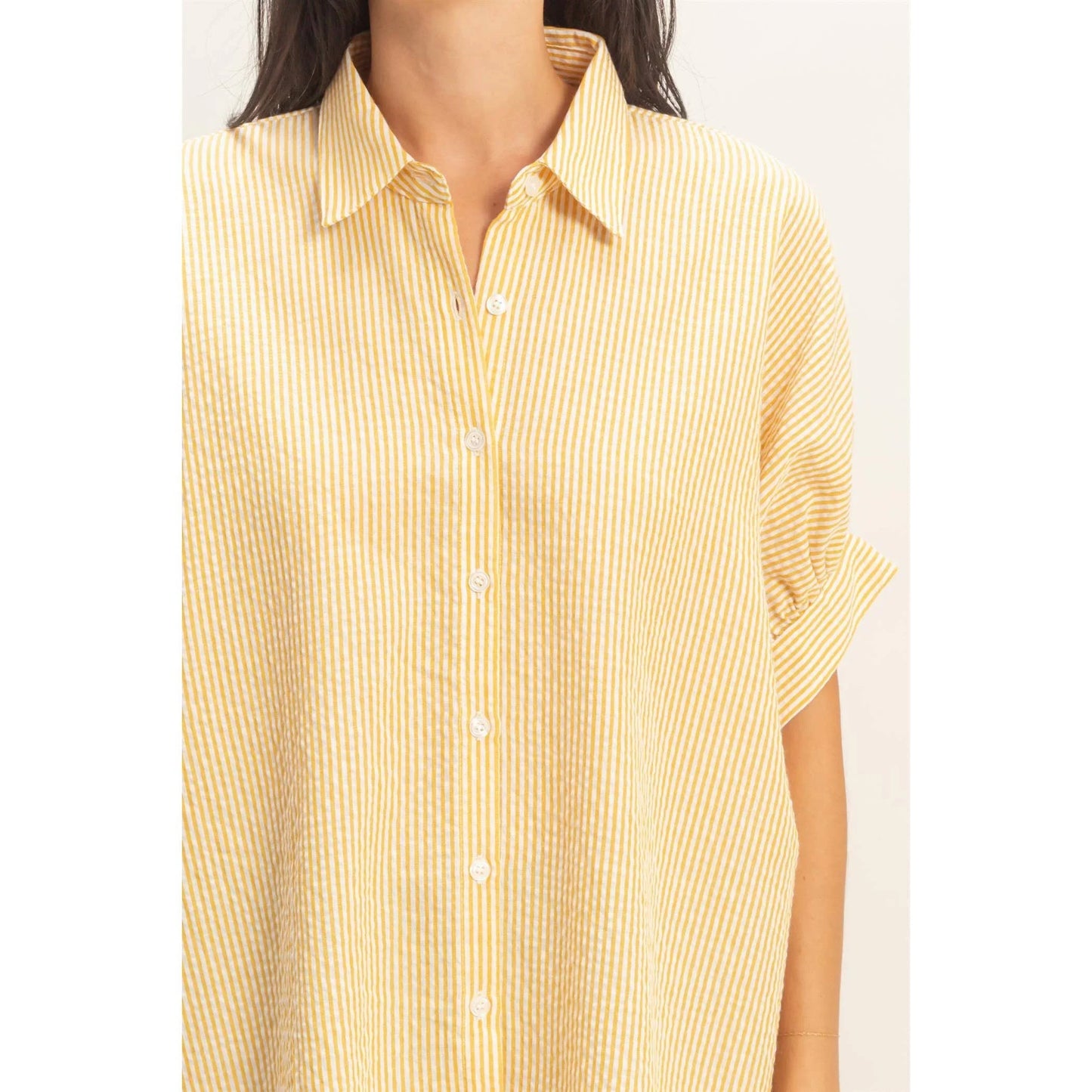 Yellow and white striped button-up shirt with short sleeves and collar
