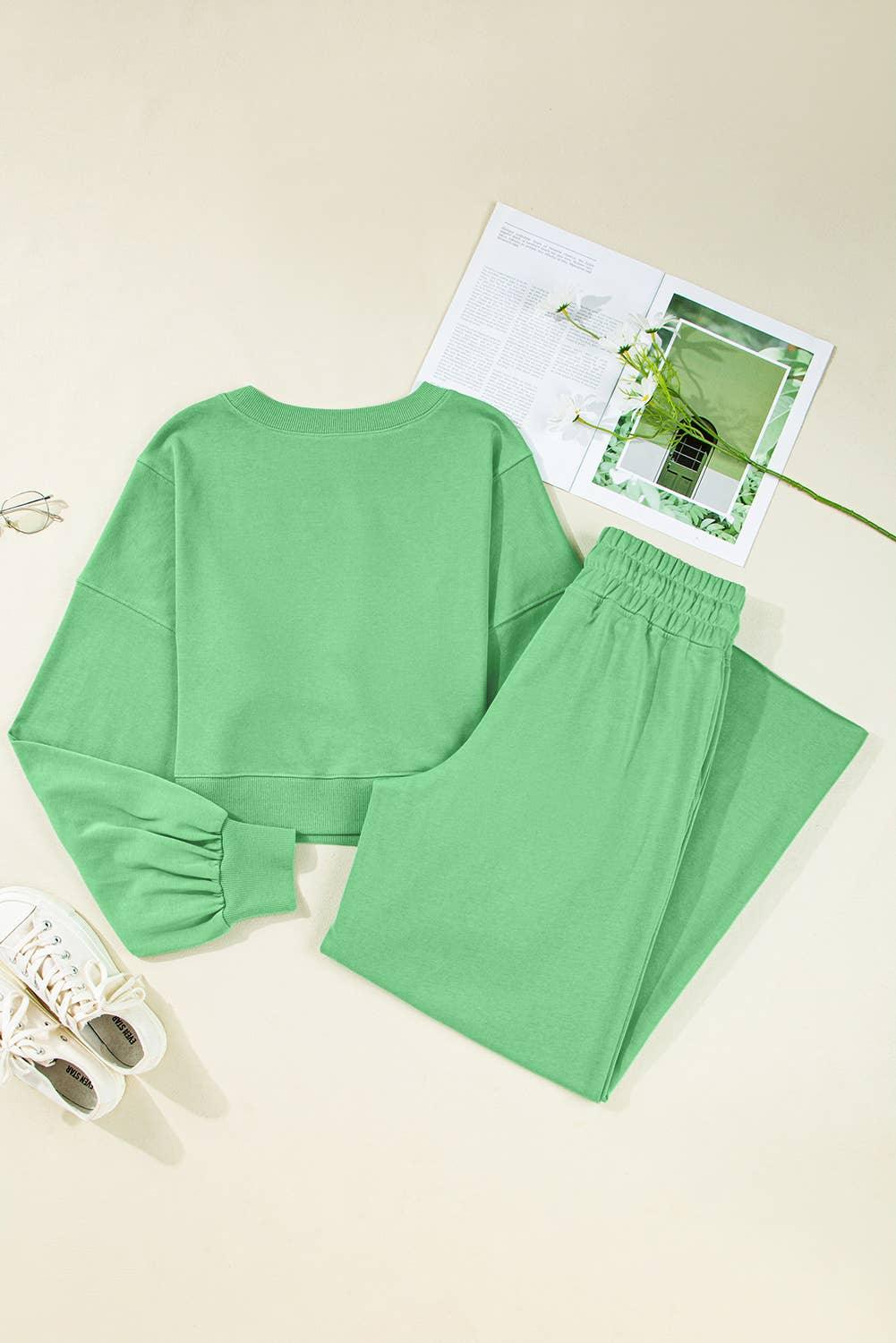 Green loungewear set with long sleeve top and pants, styled with white sneakers and glasses