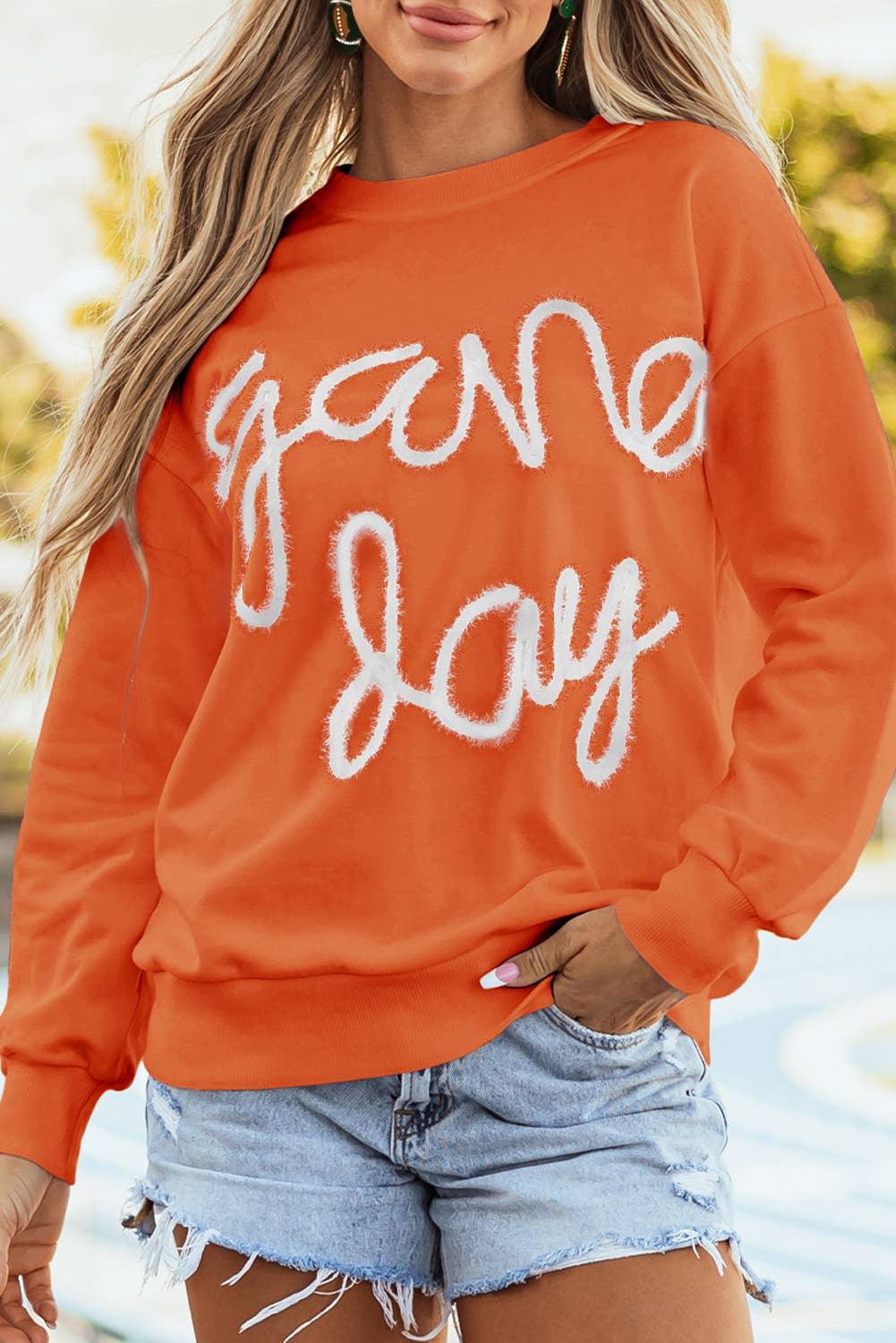 Orange 'Game Day' graphic sweatshirt with distressed denim shorts, casual fall fashion