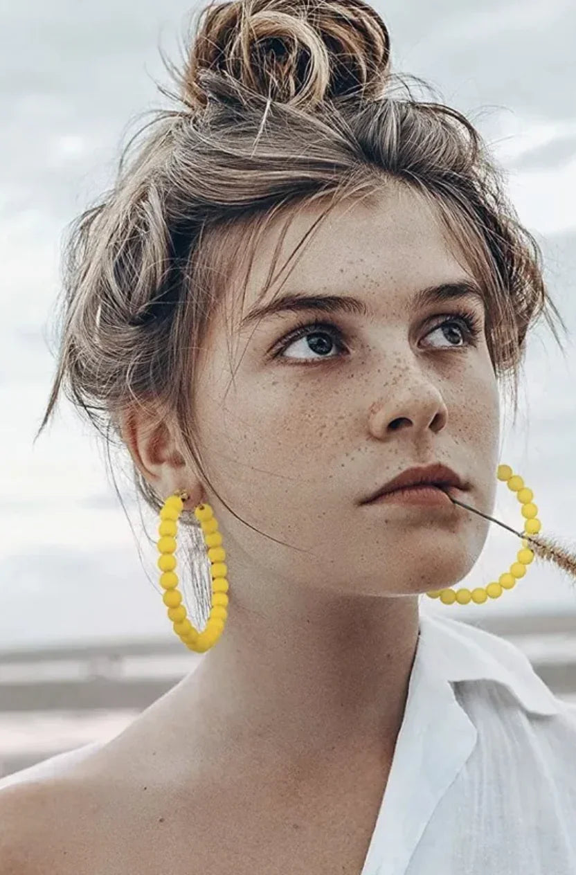 Yellow beaded hoop earrings with white blouse, beach style fashion accessory