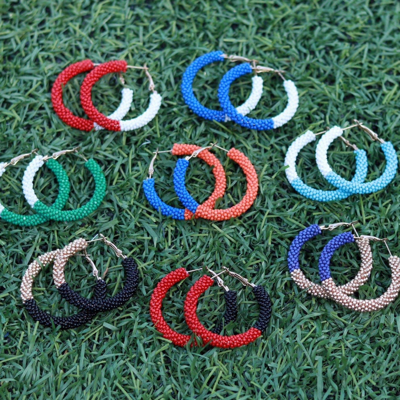 Colorful beaded hoop earrings in various pairs displayed on grass