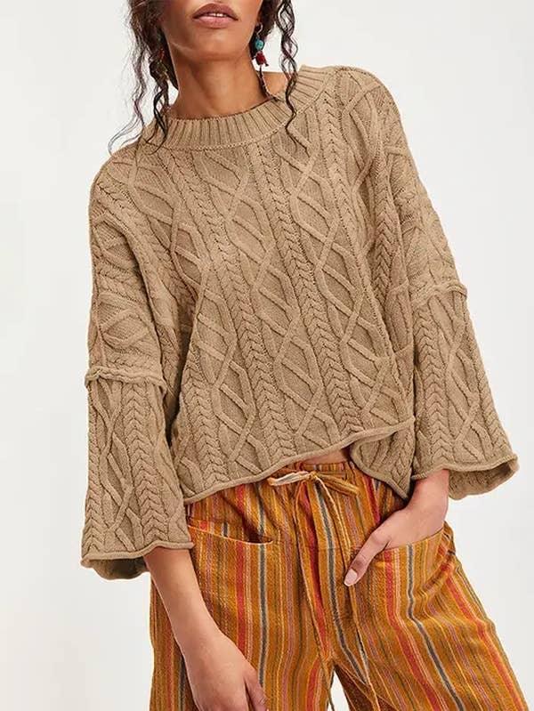 Woman wearing a chunky knit beige sweater and striped wide-leg pants, casual fall fashion