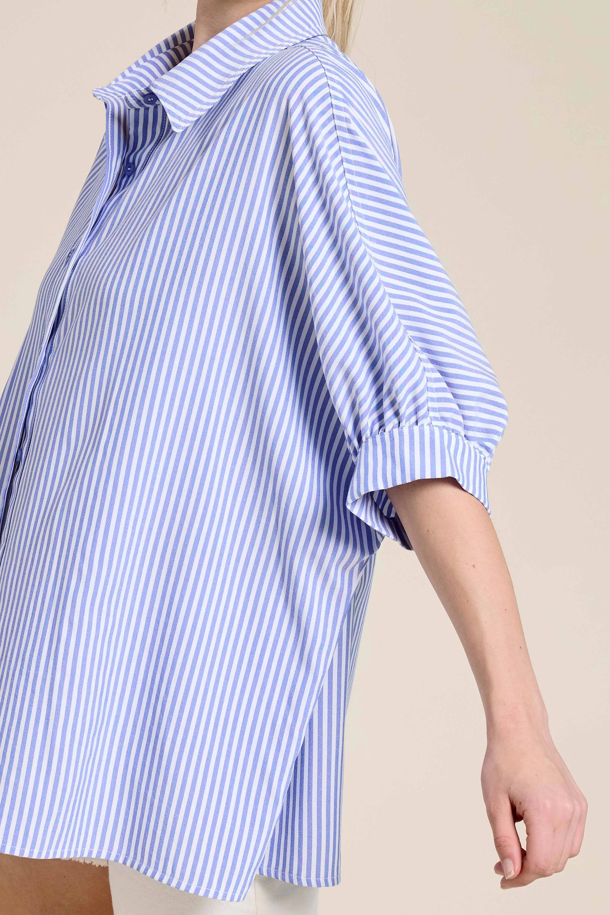 Blue and white striped oversized button-up shirt with short sleeves on model