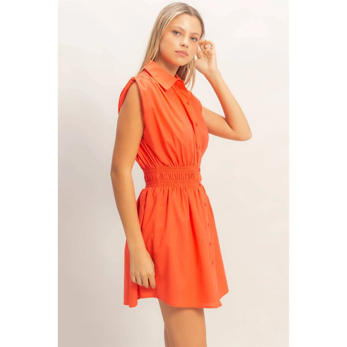 Vibrant orange sleeveless button-front dress with smocked waist, perfect for summer fashion and casual style.