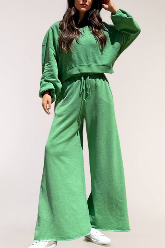 Woman wearing green oversized lounge set with wide leg pants and white sneakers