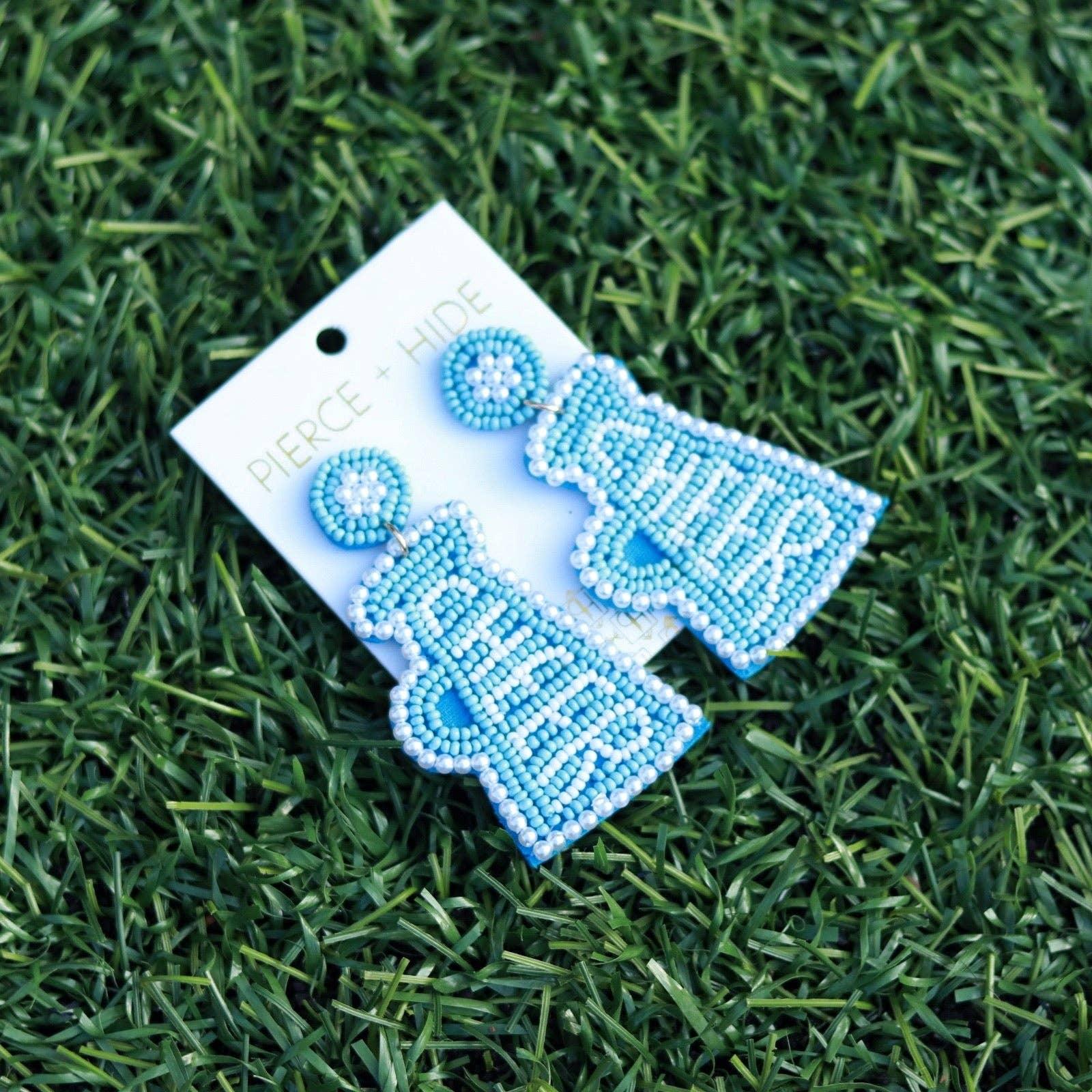 Blue and white beaded cheerleader megaphone earrings on grass background