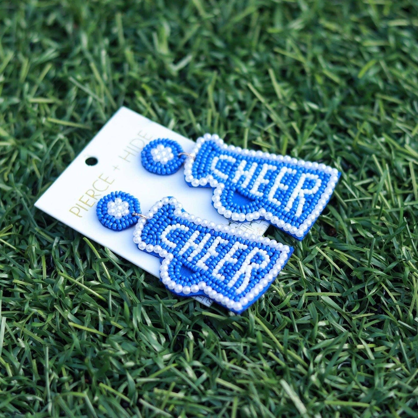 Blue beaded cheer megaphone earrings on grass, statement accessory for cheerleading fans