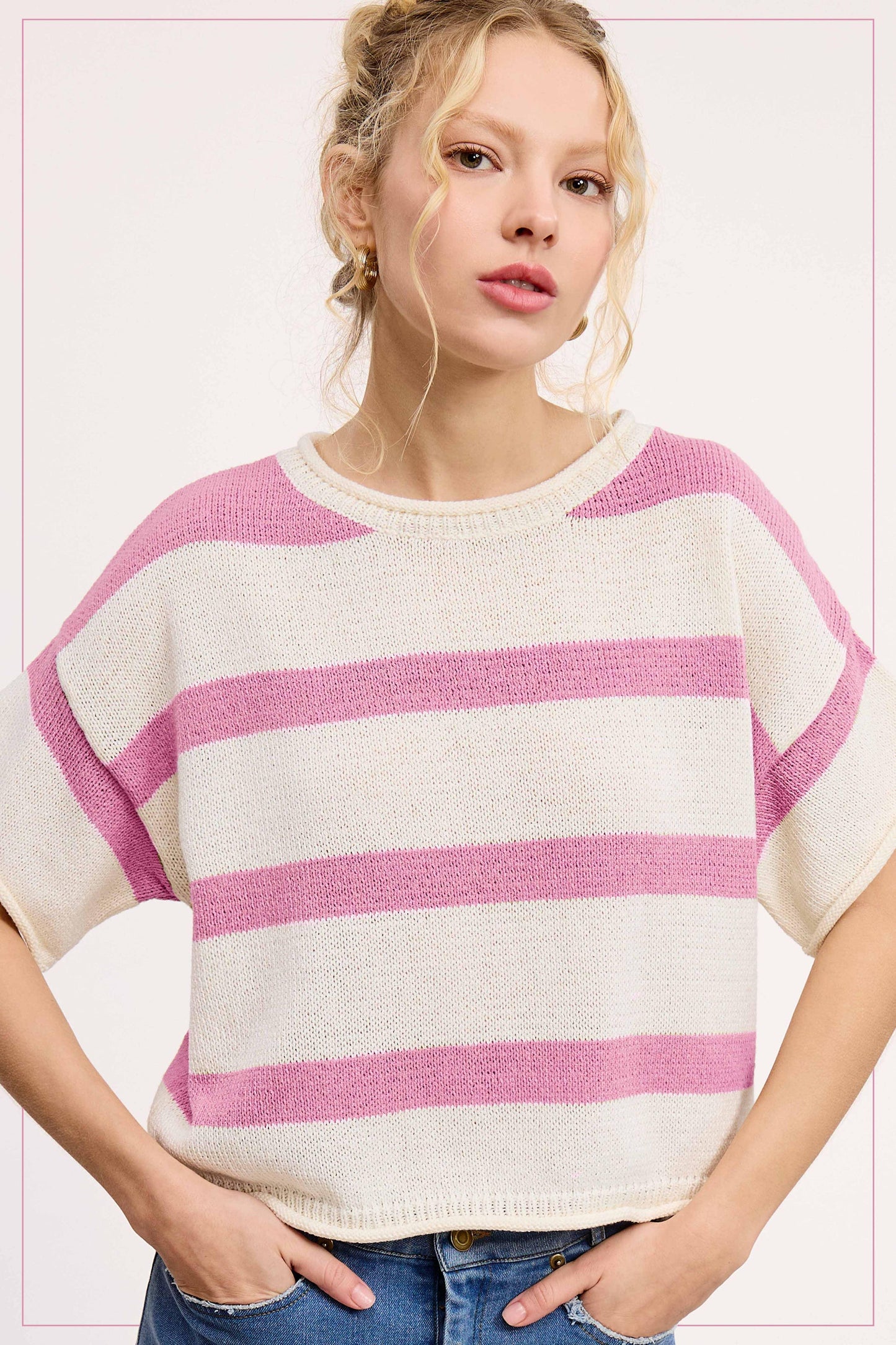 Woman wearing a pink and white striped knit short sleeve sweater and blue jeans