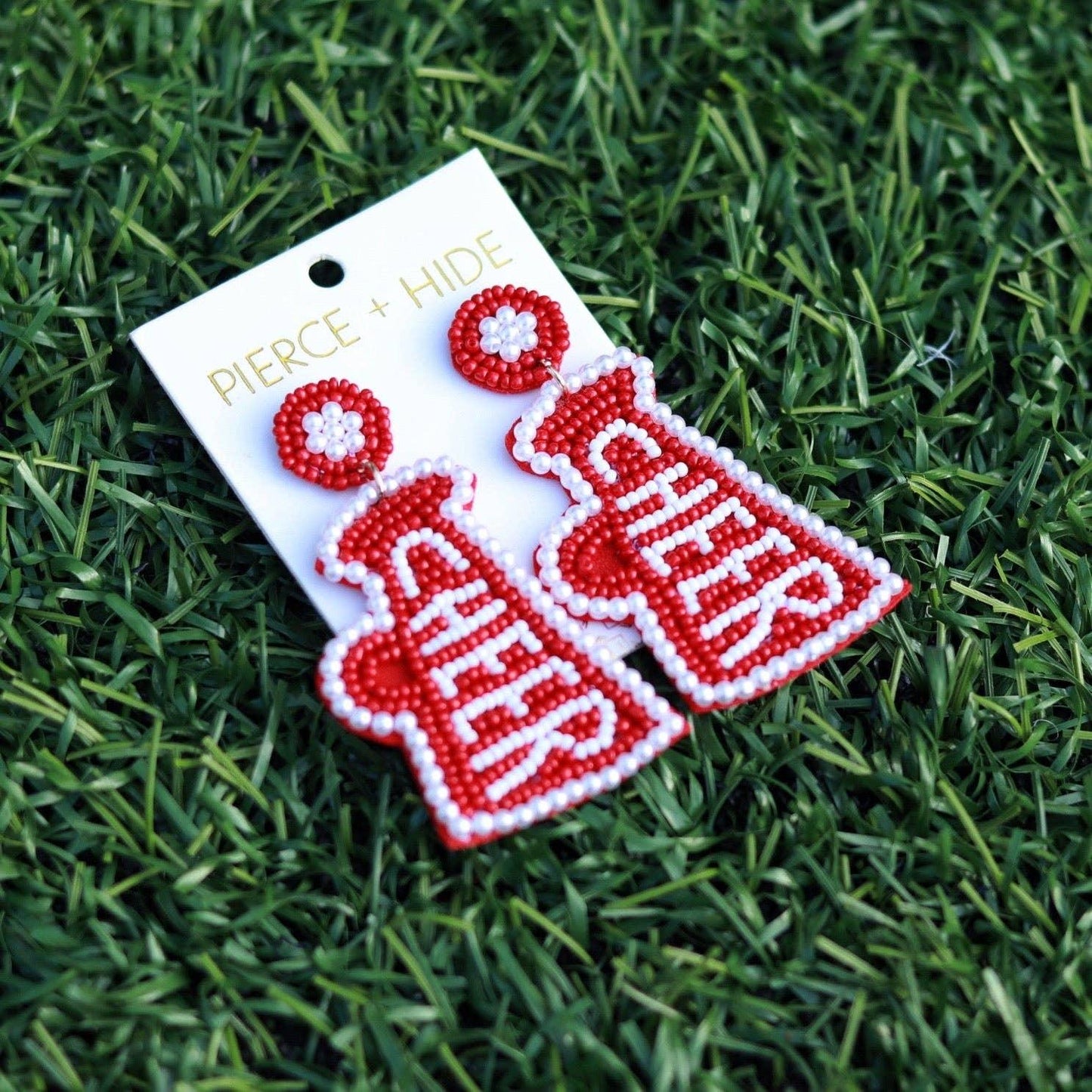 Red beaded cheer megaphone earrings on grass, handmade statement accessory