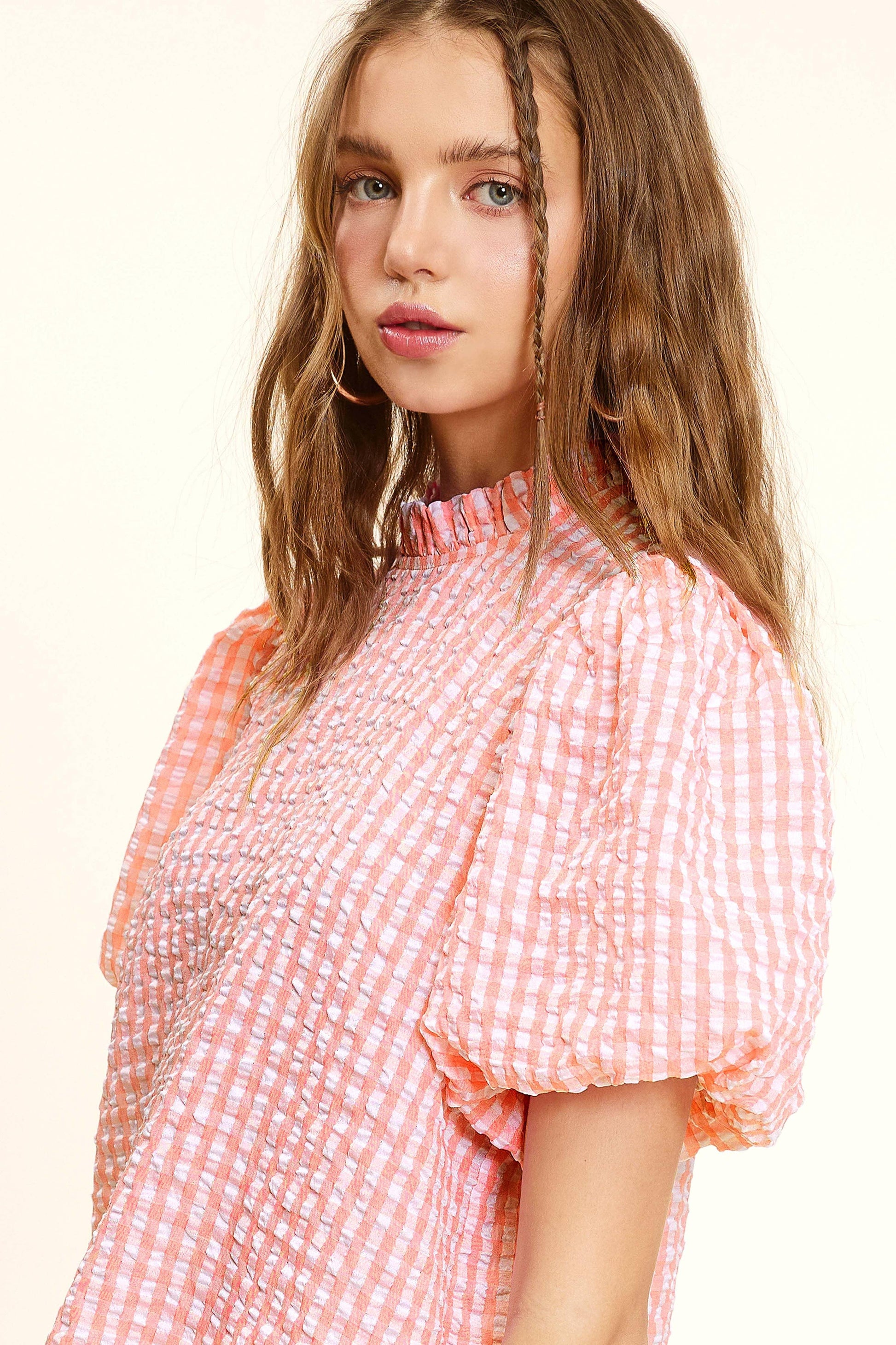 Woman modeling pink and white checkered puff sleeve blouse from Lou's Boutique