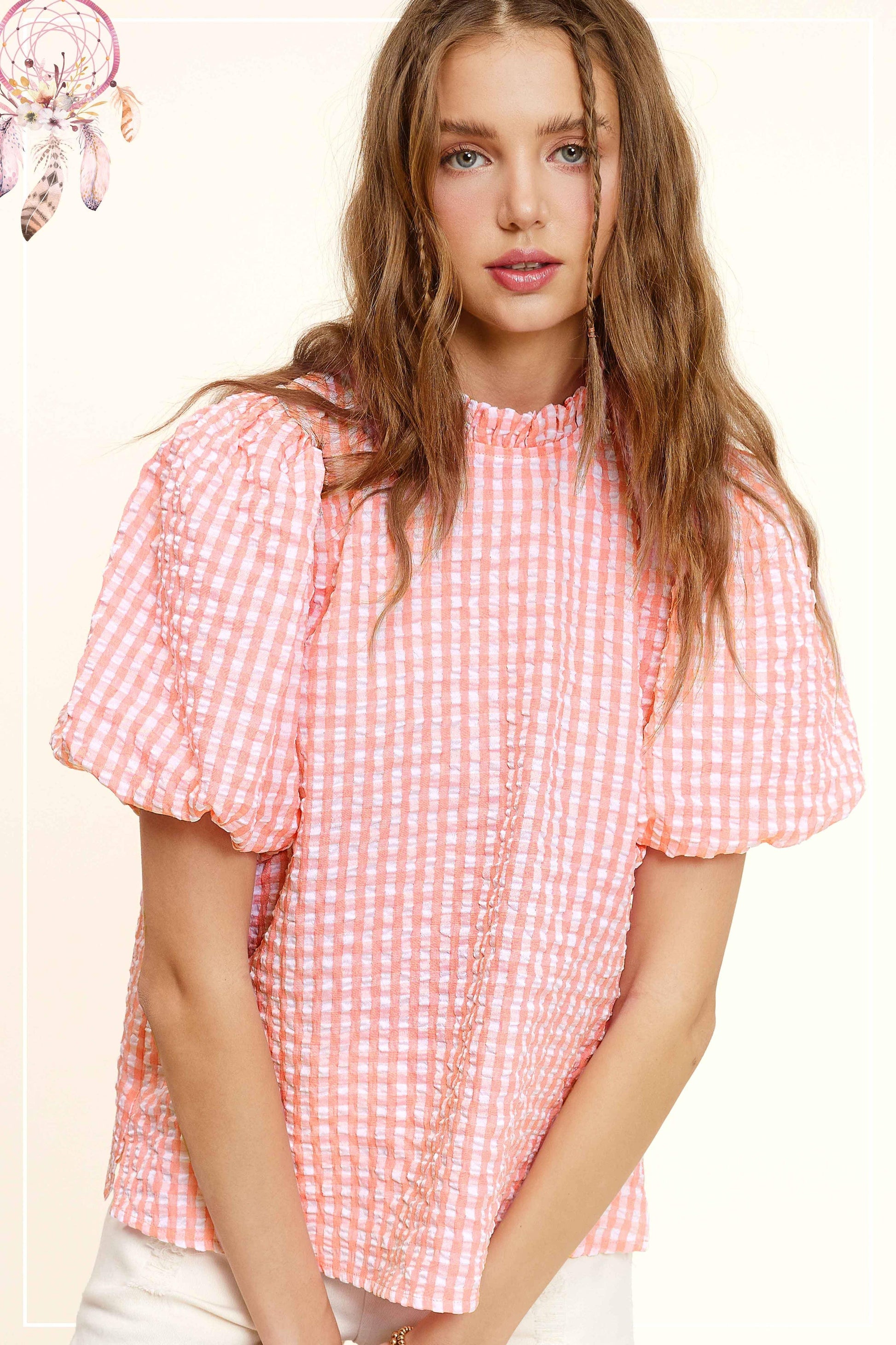 Woman wearing a pink gingham puff sleeve blouse from Lou's Boutique
